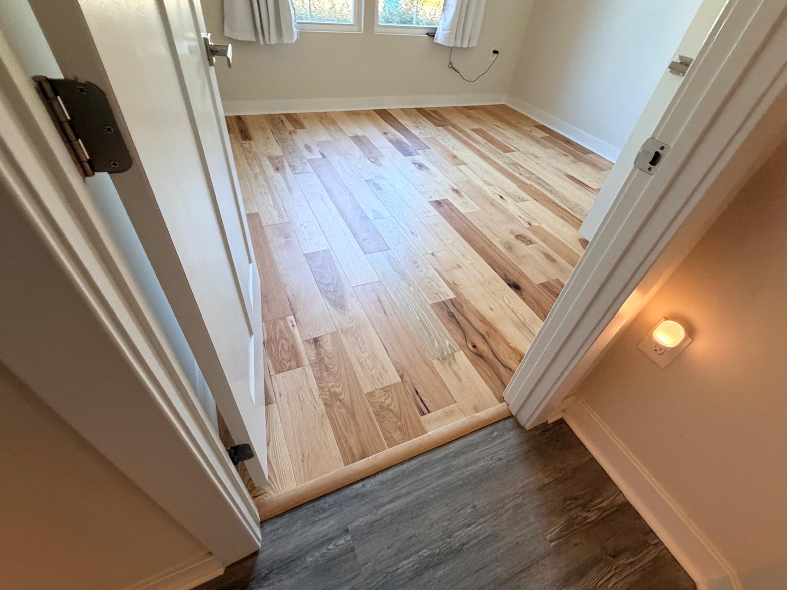 Mixed-tone hickory hardwood installation in bedroom