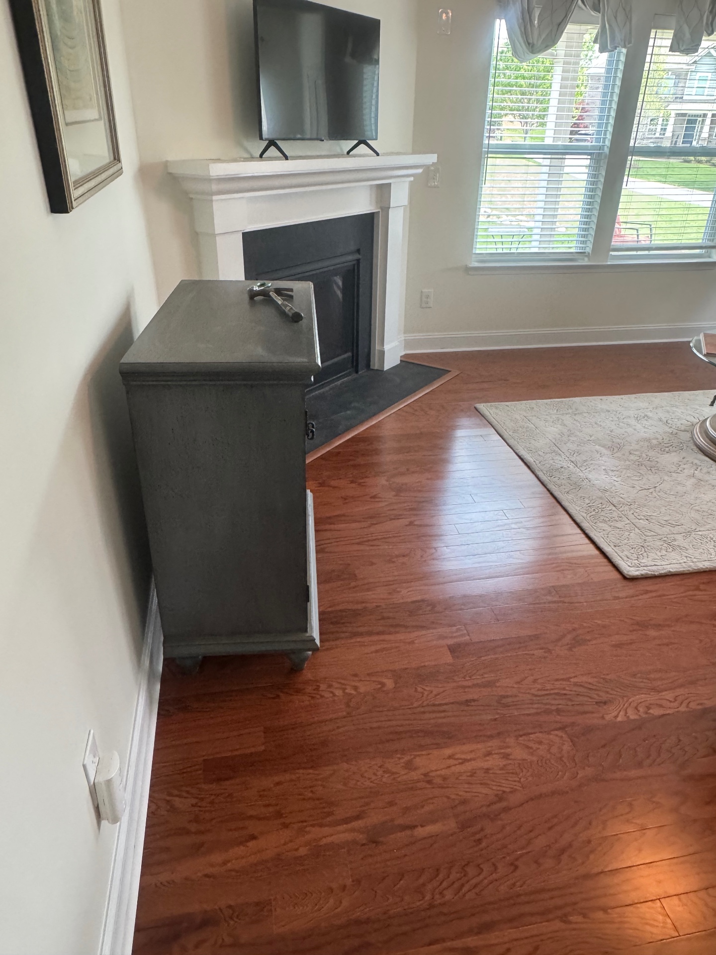 Rich cherry oak hardwood flooring around fireplace and mantel